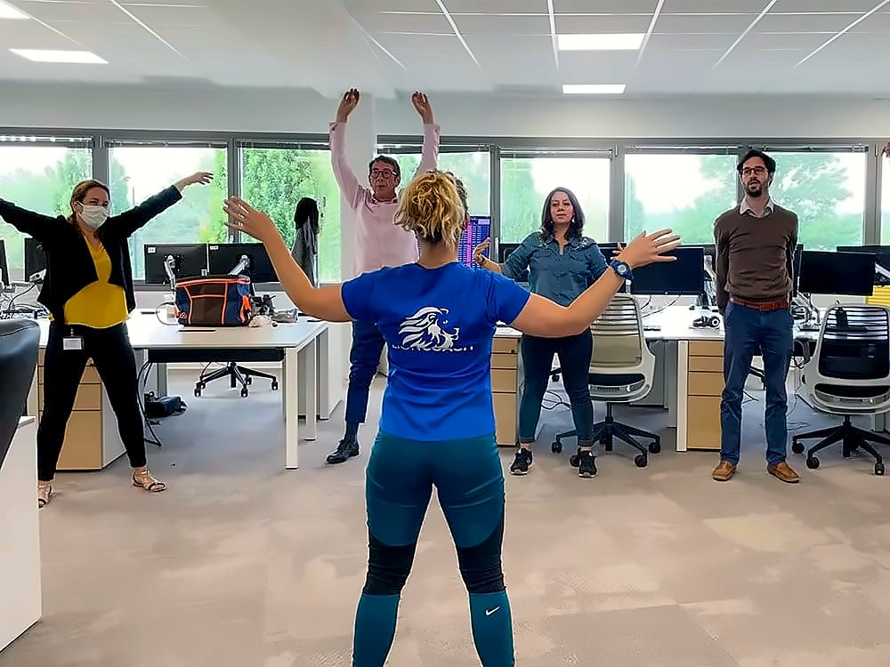 Séance d'étirements avec une coach dans un open space